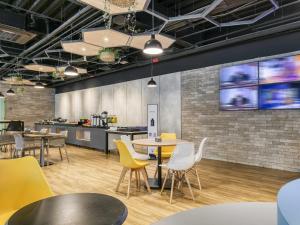 a restaurant with tables and chairs and a kitchen at ibis budget BH Savassi in Belo Horizonte +55 photos