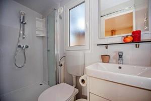 ein Badezimmer mit Toilette, Waschbecken und Dusche in der Unterkunft Eurocamp Mobile Homes at Campsite Puntica in Funtana + 46 Fotos