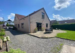 a brick house with a patio in a yard at La Maison de Mel in Bois le Duc