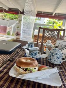 a sandwich on a plate on a table with a laptop at Villa Josephine in Paramaribo