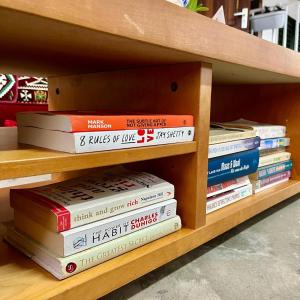 a stack of books sitting on a shelf at Villa Josephine in Paramaribo