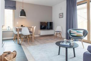 a living room with a table and chairs and a tv at Sylt Lofts in Westerland (Sylt)