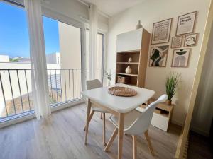 een witte tafel en stoelen in een kamer met een balkon bij Studio Design & Cosy - Accès Ile de Ré & Plages - WIFI PARKING GRATUIT in La Rochelle +5 foto's