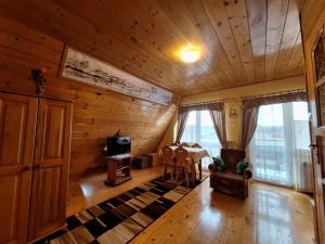 a living room with wooden walls and a wooden ceiling at DW Jastrun in Białka Tatrzanska