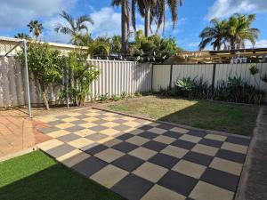 a backyard with a checkeredkered floor and a fence at Tweebine Villas in Utakarra