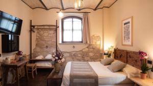 une chambre avec un grand lit et une fenêtre dans l'établissement Borgo Degli Angeli Resort e Spa, à San Vitale