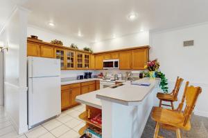 een keuken met houten kasten en een witte koelkast bij The Abilene at Judith Ann Inn in Oyhut +11 foto's