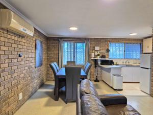 a kitchen and living room with a table and chairs at Tweebine Villas in Utakarra