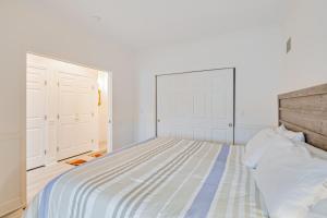 ein Schlafzimmer mit einem Bett und einer weißen Wand in der Unterkunft The Charleston at the Judith Ann Inn in Oyhut