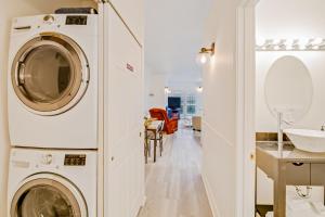 eine Waschküche mit Waschmaschine, Trockner und Waschbecken in der Unterkunft The Charleston at the Judith Ann Inn in Oyhut