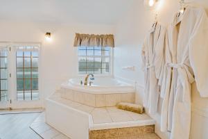 ein weißes Badezimmer mit Badewanne und Fenster in der Unterkunft The Charleston at the Judith Ann Inn in Oyhut + 15 Fotos