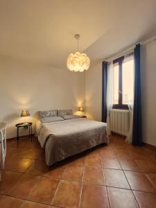 a bedroom with a large bed and a chandelier at YAWHome B&B in Bologna