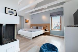 een slaapkamer met een bed en een open haard bij Sylt Lofts in Westerland