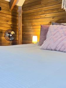 a bedroom with a bed with a fan and wooden walls at Chalet Boutique a 7 Min del Aeropuerto JMC in Guarne