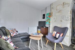 ein Wohnzimmer mit Sofa und Tisch in der Unterkunft Appartement T2 indépendant au coeur de la ville in Bourges