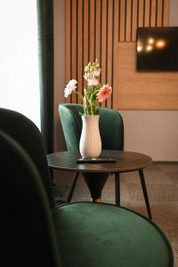 a vase of flowers sitting on a table with chairs at R Zajazd Witnica in Witnica