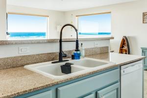 a kitchen sink with a view of the ocean at Ocean Breeze in Westport +22 photos