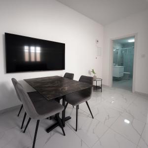 a dining room with a table and chairs and a flat screen tv at Limassol Centr Apartament in Limassol