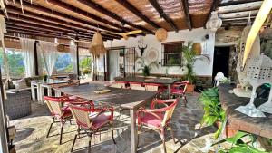 ein Wohnzimmer mit Tischen und Stühlen und einer Couch in der Unterkunft Padre Sol Yoga Retreat Center Málaga by AndaraHolidays in Sayalonga