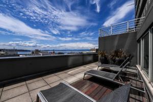 a balcony with chairs and a view of the ocean at Newmark Jewel in Seattle