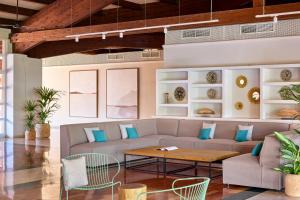 a living room with a couch and a table and chairs at Sol Falco Menorca in Son Xoriguer