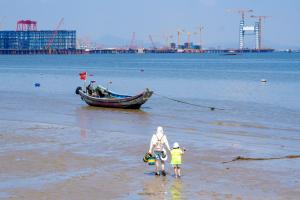 two people on the beach with a boat in the water at Shangri-La Xiamen in Xiamen +54 photos