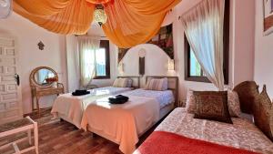 ein Schlafzimmer mit zwei Betten und einer Couch in der Unterkunft Padre Sol Yoga Retreat Center Málaga by AndaraHolidays in Sayalonga