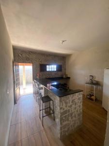 een keuken met een aanrecht met stoelen en een tafel bij Casa imperr in Aracati