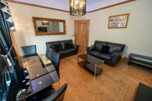 a living room with two leather couches and a table at Roomy home 1 level Free Parking in Edinburgh +18 photos