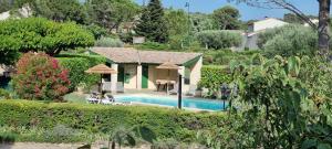 a villa with a swimming pool and a house at Hôtel Le Pradet in Vacqueyras
