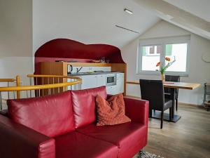 a living room with a red couch and a table at Birkhofer See genießen - Aparthotel am Bodensee in Immenstaad am Bodensee