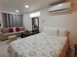 a bedroom with a bed and a couch at Tocumen Airport Los Corcho Suites in Tapia Número Dos