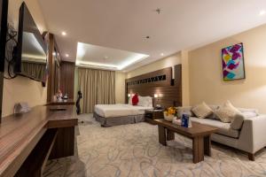 a hotel room with a bed and a couch at Sumou Al Khobar Corniche in Al Khobar