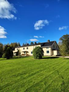 a large white house with a large green field at Livning Horndal in Horndal