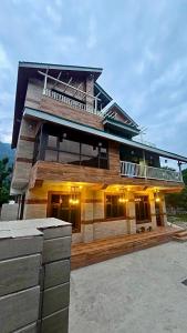 a large wooden house with a lot of windows at Cloud Culture Villa in Baragrān