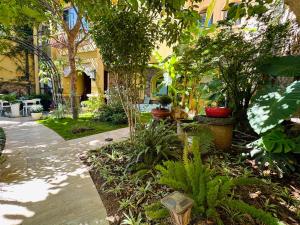 a garden with trees and plants in front of a building at Dali Tanuki Fantasy Seaview Villa in Dali