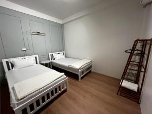 バンコクにあるCozy Oldtown Near MRT HuaLumpongの小さな部屋 ベッド2台 ハシゴ付