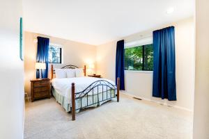 Schlafzimmer mit einem Bett und blauen Vorhängen in der Unterkunft Lake Chelan Shores - Sunny by the Lake 18-4 in Lakeside + 29 Fotos