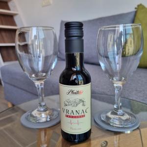 une bouteille de vin et deux verres à vin sur une table dans l'établissement Tivat Cocoon Studio, à Tivat 7 autres photos