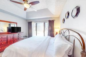 a bedroom with a bed with a ceiling fan and a tv at Camp Warnecke Estates Unit B104 in New Braunfels