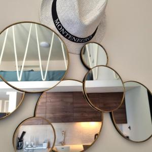 un groupe de miroirs circulaires suspendus sur un mur dans l'établissement Tivat Cocoon Studio, à Tivat