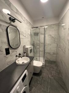 a bathroom with a toilet and a sink and a shower at Mieszkanie Apartament stylowy zadbany parking parter in Słupsk
