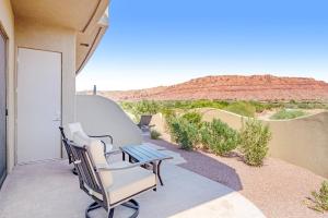 a porch with two chairs and a table with a view of the desert at Red Rock Suite in Santa Clara