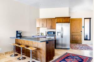 a kitchen with wooden cabinets and a stainless steel refrigerator at Red Rock Suite in Santa Clara