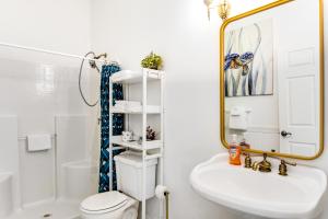 een badkamer met een wastafel, een toilet en een spiegel bij The Marietta at Judith Ann Inn in Oyhut +10 foto's