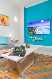 a laptop sitting on a coffee table in a living room at Choose To Be Happy at The Westbury - Two Bedroom Apartment in Kingston
