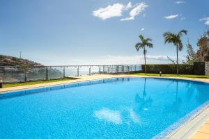 a large swimming pool with a view of the ocean at Calheta, Sun, Sea & Pool in Calheta
