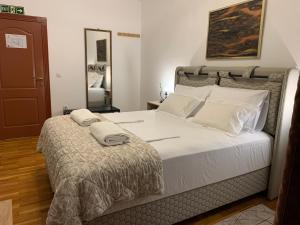 une chambre avec un grand lit avec des draps blancs dans l'établissement Diplomat Haven, à Sremska Kamenica