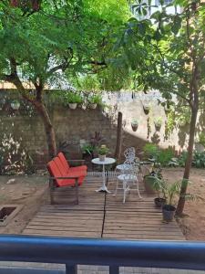 een houten terras met een rode stoel en een tafel bij Apartamento térreo com 2 quartos e jardim in Teresina