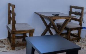 two chairs and a wooden table and a table and a chair at Sinty's furnished homes in Narok